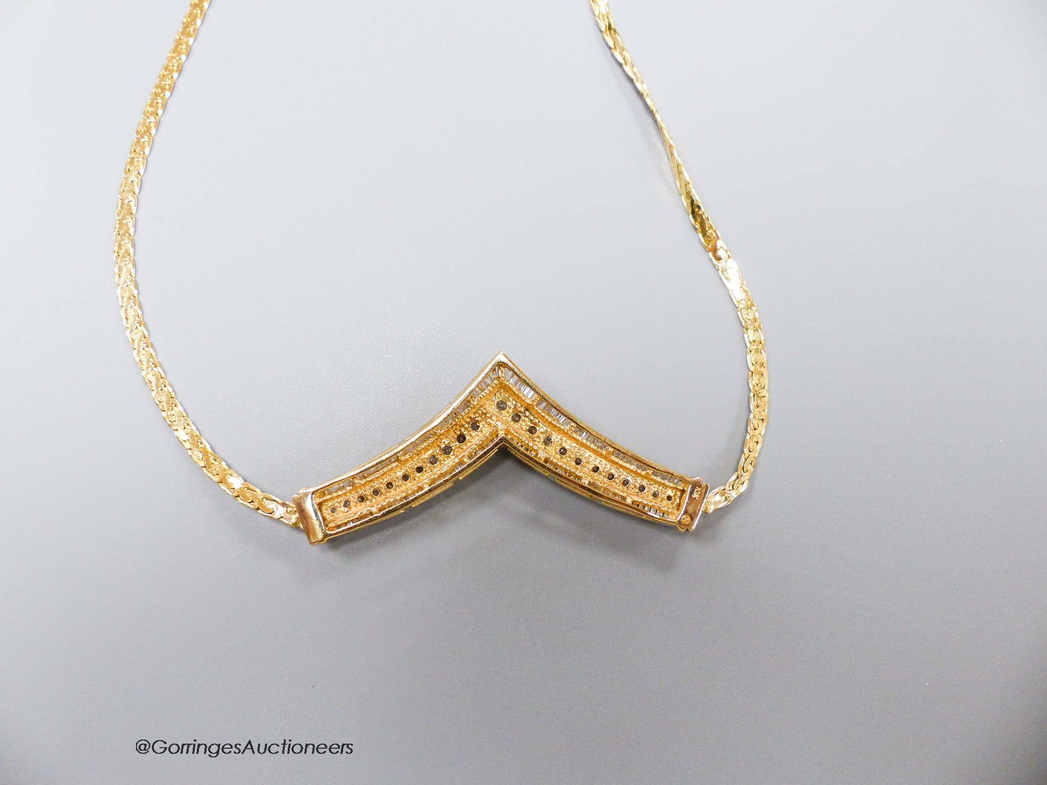 A 10k yellow metal diamond set 'herringbone' necklet, on a 14k yellow metal chain, gross weight 15.6gms.